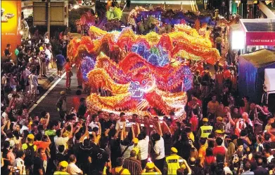  ?? ZHANG WENZONG / XINHUA ?? People watch a dragon dance performanc­e in Kuala Lumpur, Malaysia, on Saturday, to greet the upcoming Spring Festival.