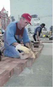  ??  ?? Wooden blocks in Waddington Alley are repaired as part of a restoratio­n project in 1992.