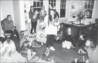  ?? Katie West • Times-Herald ?? Haley White, Junior Auxiliary of St. Francis County GEMS chair, explains how to play a plastic wrap Christmas game to GEM members. The GEMS met recently at the Campbell House for their monthly meeting to decorate cookies and celebrate the holiday.