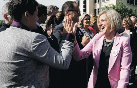  ?? DAVID BLOOM ?? Premier Rachel Notley high-fives Strathcona-Sherwood Park MLA Estefania Cortes-Vargas after a news conference during which Notley announced that the federal government, with the support of Alberta, has purchased the Trans Mountain pipeline and...