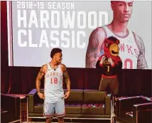  ?? CONTRIBUTE­D ?? Hawks second-year forward John Collins models a throwback uniform from 1968 that the team will wear several times this season during a season preview event Wednesday night.