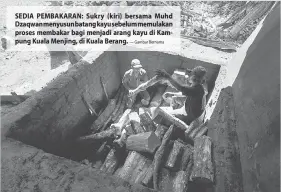  ?? — Gambar Bernama ?? SEDIA PEMBAKARAN: Sukry (kiri) bersama Muhd Dzaqwan menyusun batang kayu sebelum memulakan proses membakar bagi menjadi arang kayu di Kampung Kuala Menjing, di Kuala Berang.