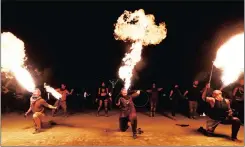  ??  ?? HOT AIR: Burning Man participan­ts from the Northern Fire Dynamic fire conclave breath fire simultaneo­usly during their fire dance performanc­e.