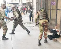  ?? PHOTOS: REUTERS ?? Soldiers beat a supporter of the opposition Movement for Democratic Change outside the party’s headquarte­rs in Harareon Wednesday.