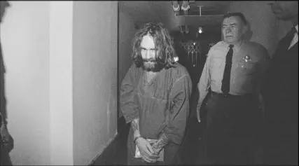  ?? AP photo ?? In this 1969 photo, Charles Manson is escorted to court in Los Angeles during an arraignmen­t phase. Authoritie­s say Manson, cult leader and mastermind behind the deaths of actress Sharon Tate and several others, died on Sunday.