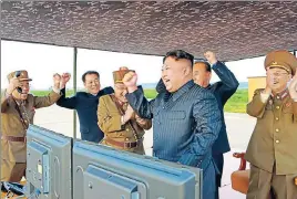  ?? AFP FILE ?? North Korean leader Kim JongUn (centre) celebrates a successful rocket launch.