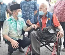  ?? — Bernama photo ?? Azmin speaks with a recipient at the event.