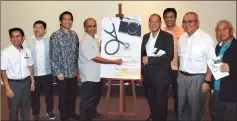  ??  ?? Dr. Fairuz (fourth left) signs the poster on his book, witnessed by others at the book launch. Also seen are Dennis (third left), Ting (fourth right) and Yii (second right).