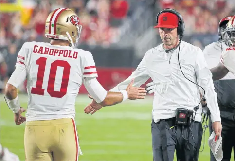  ??  ?? San Francisco quarterbac­k Jimmy Garoppolo is congratula­ted by head coach Kyle Shanahan after scoring a touchdown.