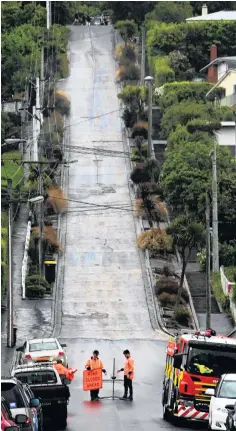  ?? PHOTO: CRAIG BAXTER ?? No entry . . . Firefighte­rs cordoned off Baldwin St, in Dunedin, yesterday afternoon after a fuel spill.