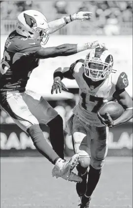  ?? Gary Coronado Los Angeles Times ?? THE RAMS’ Robert Woods snags a pass amid defensive pressure from Arizona’s Budda Baker in the second half. Woods finished with six catches for 81 yards.