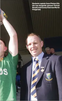  ??  ?? Dunlavin captain Sean Phelan lifts the cup alongside sponsor Patrick Murphy and County Chairman Martin Fitzgerald.