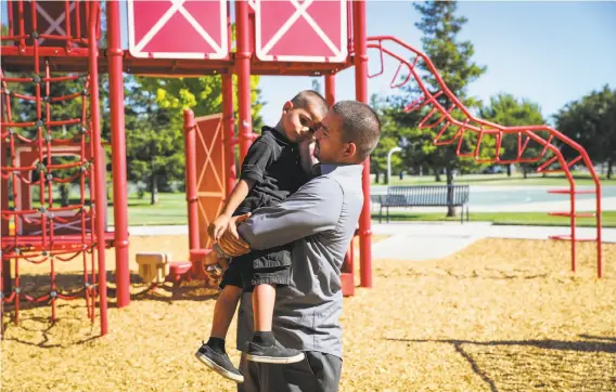  ?? Gabrielle Lurie / The Chronicle ?? Michael Provencio hugs his son, Anthony, 4, whom he and his wife adopted partly to spare the boy the turmoil Provencio himself had known as a foster child.