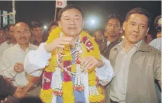  ??  ?? Thai Rak Thai leader Thaksin Shinawatra is surrounded by supporters during a campaign rally at Sanam Luang in January 2001.