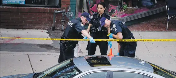  ?? CHRISTOPHE­R KATSAROV, THE CANADIAN PRESS ?? Police investigat­e a car with a bullet hole at the scene of a shooting in east Toronto on Monday.