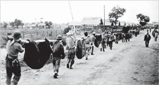  ?? U.S. MARINE CORPS ?? ABOVE: American prisoners use improvised litters to carry comrades who, from the lack of food or water on the march from Bataan, fell along the road.