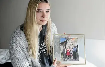  ?? CHRISTEL YARDLEY/ STUFF ?? Sophie Hartley is pictured with a family photo. Her mother, Abby Hartley, who died on Sunday, had been in a coma for more than a month in a Bali hospital after emergency surgery led to complicati­ons.