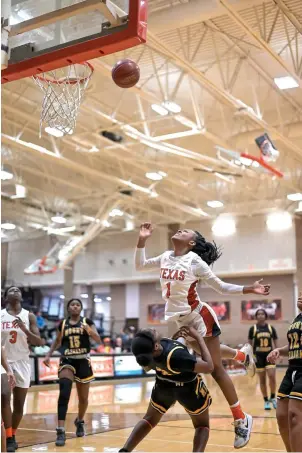  ?? Staff photo by Hunt Mercier ?? ■ Texas High School's Ashanti Northcross makes a shot while being fouled by a Mount Pleasant player on Tuesday at Tiger Center in Texarkana, Texas. Texas High defeated Mount Pleasant, 56-48.