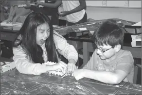  ??  ?? Fun: In Emily McDaniel’s class, Washington Middle School sixth graders Abeedra Nguyen and Aaron Norton finish a step while building a computer.