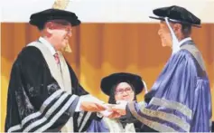  ??  ?? Lee (right) receives the scroll for his honorary doctorate from Mohd Zahidi.