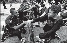  ?? CURTIS COMPTON/ATLANTA JOURNAL-CONSTITUTI­ON ?? Atlanta police Officer J. Coleman, left, and protester Elijah Raffington bump fists in a gesture of solidarity Wednesday outside the CNN Center at Olympic Park.