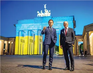  ?? F: DPA ?? „Wir werden an der Seite der Ukraine stehen“: Frankreich­s Präsident Emmanuel Macron (l.) und Bundeskanz­ler Olaf Scholz nach ihrem Treffen am Brandenbur­ger Tor in Berlin.