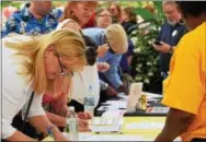  ?? MARIAN DENNIS — DIGITAL FIRST MEDIA ?? As groups showed up for the vigil Thursday night, attendees lined up at tables to sign a petition denouncing racism and hate.