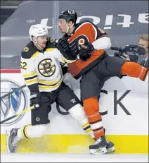  ?? AP ?? Boston’s Sean Kuraly, left, and Philadelph­ia’s Justin Braun collide during the second period of Saturday’s game in Philadelph­ia.