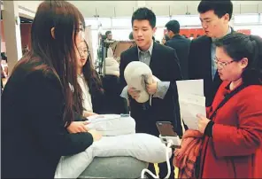  ?? PROVIDED TO CHINA DAILY ?? Employees from Seblong Technology (Beijing) Co Ltd introduce the smart pillow to customers at a fair in Shanghai.