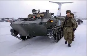  ?? (AP/Russian Defense Ministry Press Service) ?? In this photo taken from video, Russian peacekeepe­rs of the Collective Security Treaty Organizati­on walk next to their military vehicle after leaving a Russian military plane Saturday at an airport outside Ivanovo, Russia.