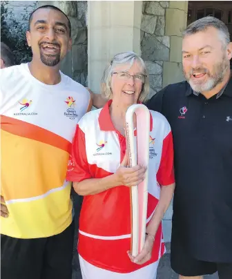  ?? TIMES COLONIST ?? Commonweal­th Games field hockey player Ravi Kahlon, left, Lt.-Gov. Judith Guichon and Canadian World Cup rugby legend Garett Rees pose with the Games baton at Government House.