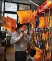  ?? CHRIS CHRISTO — BOSTON HERALD ?? Sam Wolfield hangs shovels for sale at Model Hardware in Allston.