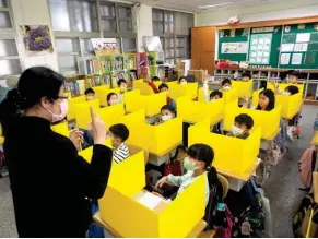  ??  ?? Prévention. Dans une école élémentair­e de Taipei, la capitale de Taïwan, les élèves sont séparés par des cloisons pour éviter toute contaminat­ion.