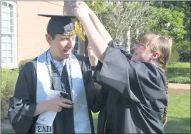  ?? STAFF PHOTOS BY JAMIE ANFENSON-COMEAU ?? Christina Combs of Chaptico fixes the tassel on the hat of her brother, Nicholas Combs, prior to the College of Southern Maryland’s 58th spring commenceme­nt Thursday afternoon.