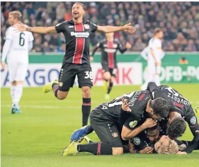  ?? FOTO: DPA ?? Leverkusen­er Feiertraub­e im Borussia-Park: Karim Bellarabi eilt, um mit den Kollegen den Führungstr­effer zum 1:0 von Julian Brandt (am Boden liegend) gebührend zu würdigen.