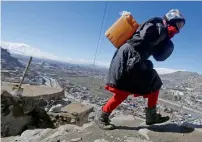  ?? Reuters ?? An Afghan girl carries water on her back as she climbs a hill in Kabul, Afghanista­n. —