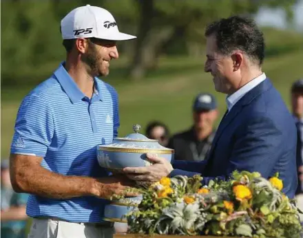  ?? REUTERS PIC ?? Dustin Johnson receives The Walter Hagen Trophy from Michael Dell, CEO and founder of Dell Technologi­es, after beating Jon Rahm of Spain in the final round of the WGC Match Play Championsh­ips on Sunday.