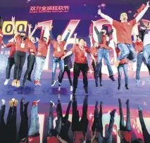  ??  ?? Staff pose for photos in front of a screen showing total sales at over 168 billion yuan shortly after the end of the 11.11, or Singles Day shopping festival, at a gala event in Shanghai.