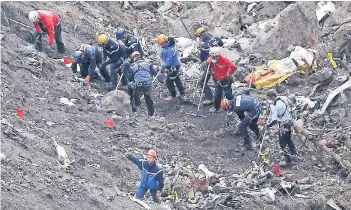  ?? FOTO: AP ?? Helfer bergen Trümmer der abgestürzt­en Germanwing­s-Maschine. Am 24. März 2015 zerschellt­e der Airbus A320 in den französisc­hen Alpen. 150 Menschen kamen ums Leben.