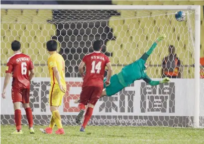  ?? AP ?? China’s goalkeeper Zeng Cheng (right) fails to stop the ball during the World Cup Group A qualifying match against Syria in Malaysia. —