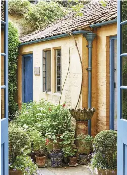  ??  ?? ABOVE Glazed double doors from the kitchen open into the courtyard garden, in which there is a well, and a pit for slaking lime FACING PAGE From the entrance hall, there is a view past the stairs to the kitchen. The glazed partition on the left was...