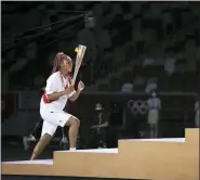  ?? HANNAH MCKAY — POOL PHOTO VIA AP ?? Naomi Osaka carries the Olympic Torch during the opening ceremony in the Olympic Stadium at the 2020 Summer Olympics, Friday, July 23, 2021, in Tokyo, Japan.