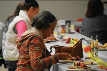  ?? MARIAN DENNIS — DIGITAL FIRST MEDIA ?? Turkey, stuffing, green beans and sweet potatoes were among some of the holiday foods served during a community Thanksgivi­ng meal put on by area churches Saturday.