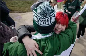  ?? JAKE MAY/THE FLINT JOURNAL VIA AP ?? Cora Fuller, 19, a Michigan State sophomore from Macomb, Mich., smiles as she receives a “free mom hug” from Sue Dodde, a mother from Conklin, in East Lansing, Mich., on Monday, Feb. 20.