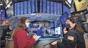  ?? Nicole Pereira / Associated Press ?? In this photo provided by the New York Stock Exchange, traders Ashley Lara, left, and Phyllis Arena Woods work on the trading floor Monday. Stocks initially rose on Monday but ended mostly lower.