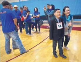  ??  ?? During a break at the state spelling bee at Sandia Prep, Samuel Le, a fifth-grader at Sandia Vista Elementary, smiles for a photo with one of his teachers, Brigid Fair.