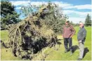  ?? PHOTO: PAM JONES ?? Dunstan Golf Course president Jim Page (left) and club captain John Richards inspect one of the trees that fell during the severe winds in Clyde yesterday.