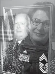  ?? NWA Democrat-Gazette/CHARLIE KAIJO ?? Elly Gibbons looks at a portrait of her late husband, retired Chief Master Sgt. John Gibbons, U.S. Air Force.