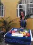  ?? JULE EISENDICK VIA AP ?? Travel and lifestyle writer Jule Eisendick poses for a photo behind a table advertisin­g the hashtag “#plasticfre­eproduce” to help raise awareness and to show how beautiful plastic free produce looks, while on a trip in Playa Del Carmen, Mexico.