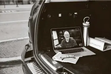  ?? Shirley Yu / New York Times ?? Jason Caldwell, a marketing manager at WordPress, a website building company, helps a client who has put Caldwell in the trunk of his car during their video call. Caldwell can work from anywhere and at any time.